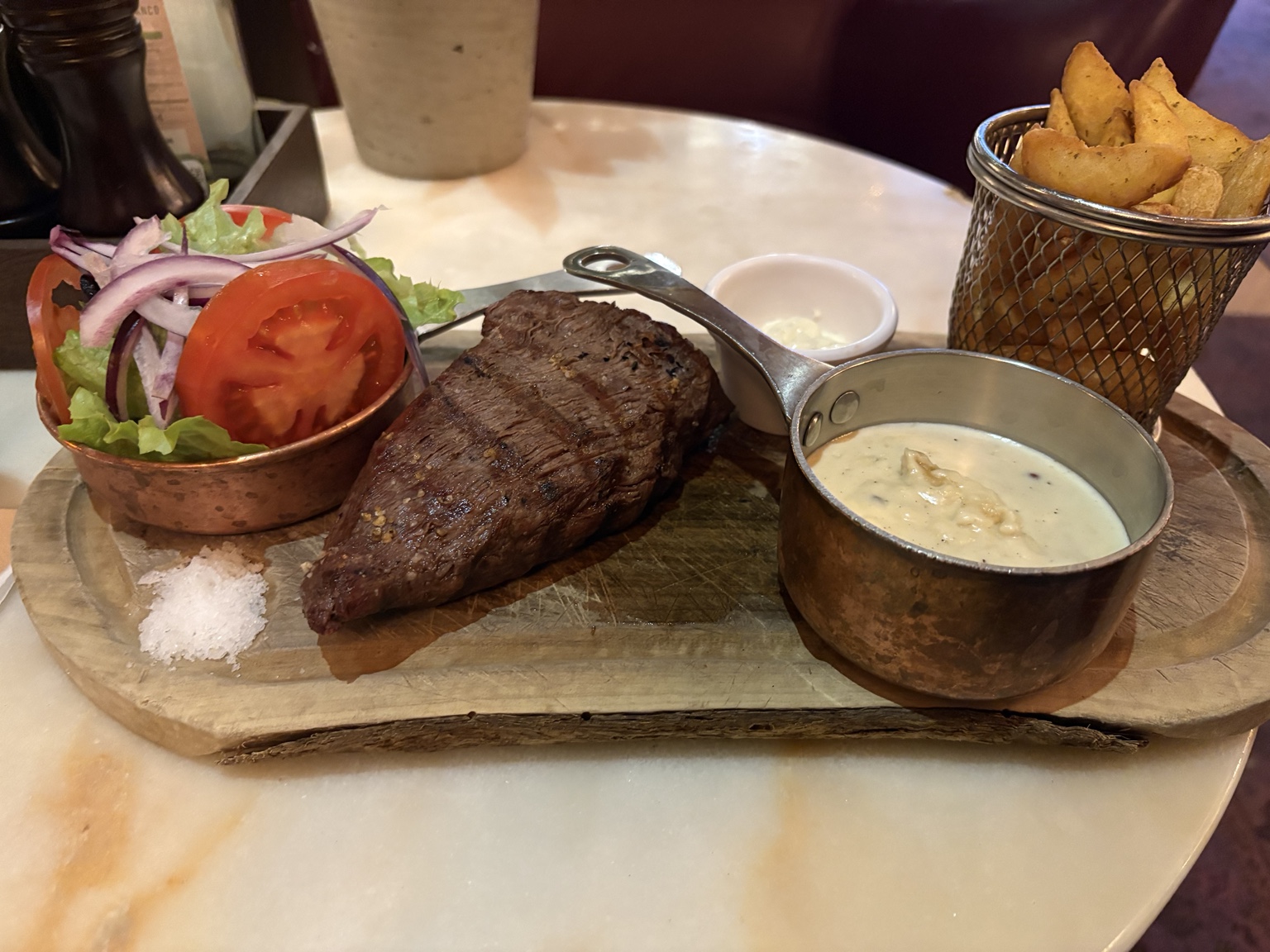 Steik, kartöflur, salat og sósa á veitingastað